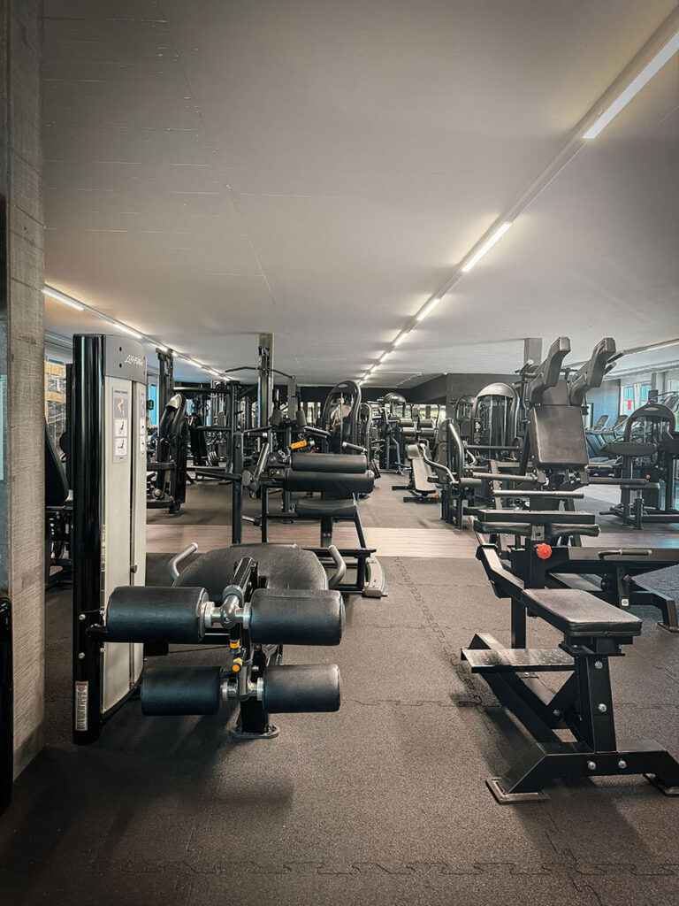 obsidian_gym_image00025 Großzügiger Gerätebereich im OBSIDIAN Premium Fitness Studio in Sursee mit Kraftmaschinen, Trainingsbänken und moderner Trainingsfläche.