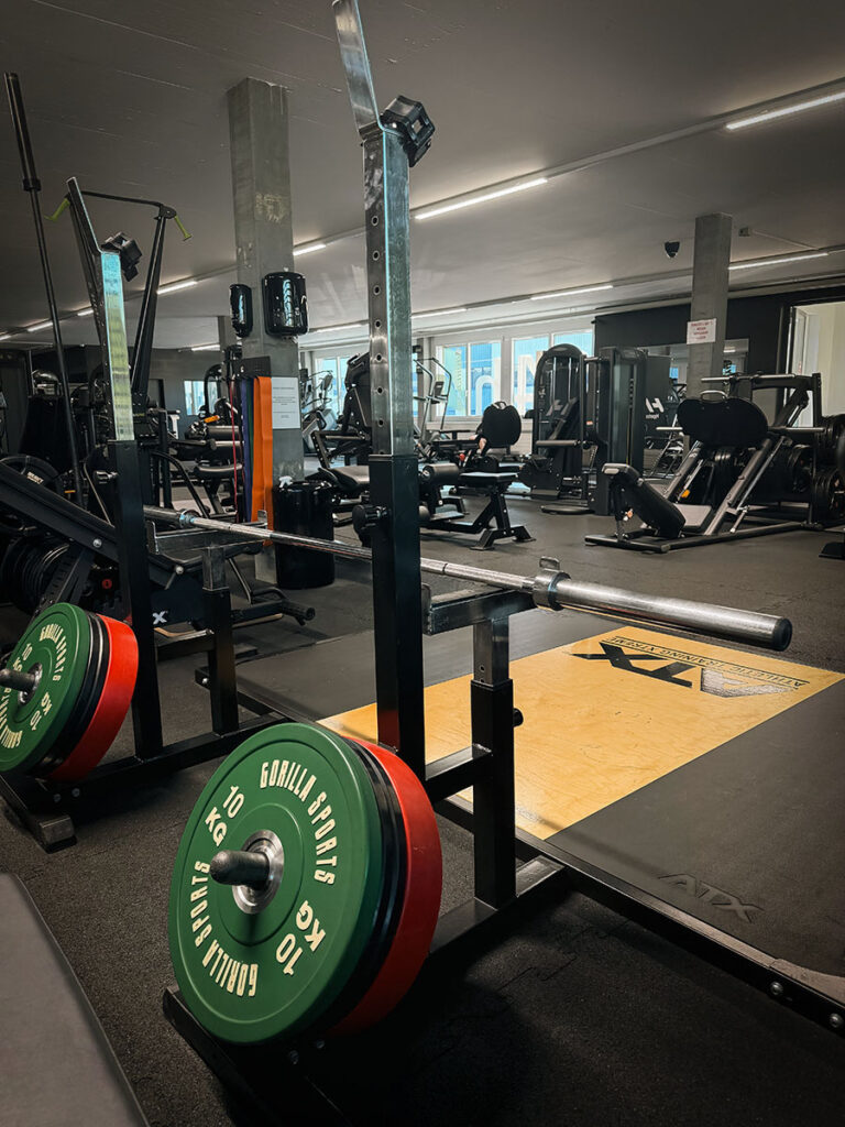 obsidian_gym_image00029 Powerlifting-Bereich im OBSIDIAN Premium Fitness Studio in Sursee mit Squat Rack, Langhantel, Gewichtsscheiben und Hebeplattform.